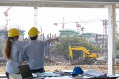 Engineer group and worker meeting, discussion with construction blueprint on site work and point finger to the work site